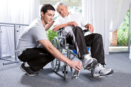 Caregiver helps man in wheelchair